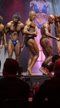 AB Physique coach on stage with fellow competitors at bodybuilding competition